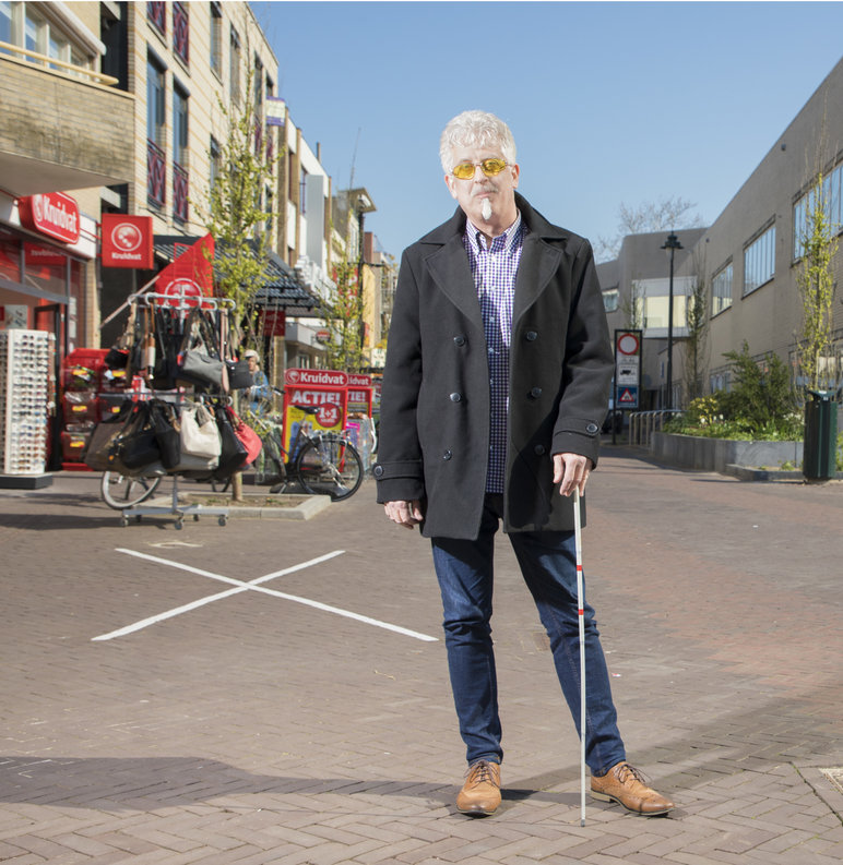 Foto van Fred ten voeten uit in een winkelstraat