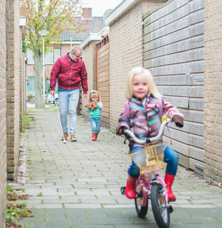 Foto van Wolter met zijn jongste dochter aan de hand en de oudste op haar eigen fiets