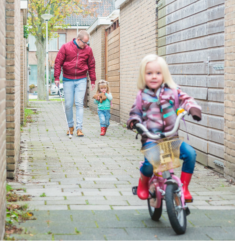 Foto van Woter op straat met een dochter aan de hand en de ander op haar eigen fiets